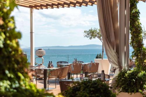 a patio with a table and chairs and a view of the ocean at Radisson Blu Resort & Spa in Split
