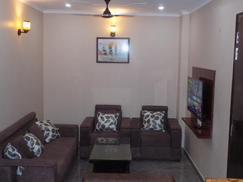 a living room with a couch and a tv at Homestay with Ravinder 2BHK in Paikbara