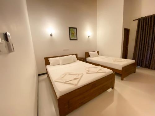 a room with two beds in a room at Yala Safari Green Home Stay in Tissamaharama