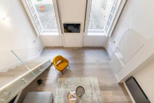 un salon avec une chaise jaune et un canapé dans l'établissement Marais - Temple, à Paris