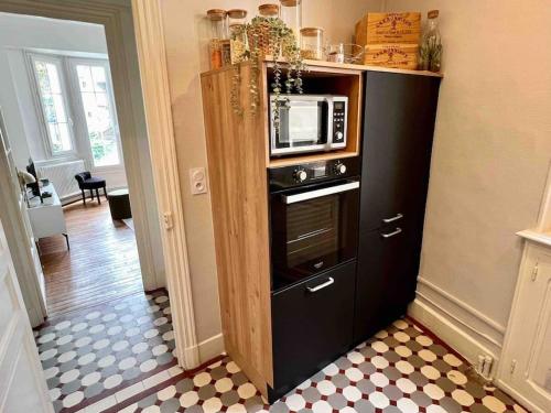 un four micro-ondes dans une armoire dans la cuisine dans l'établissement Lumineux T2 tout équipé Vichy Centre, à Vichy