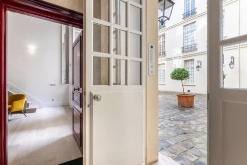 une porte menant à un couloir avec une plante en pot dans l'établissement Marais - Temple, à Paris