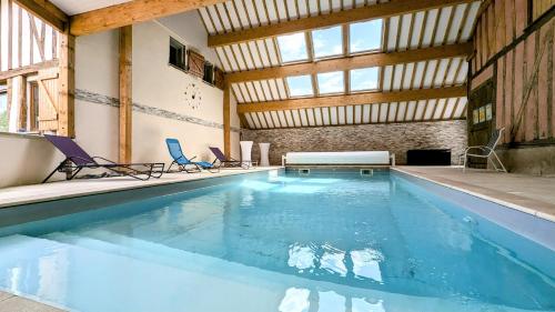 a large swimming pool with two chairs in a building at Logements calmes avec piscine, jardin et parking in Buchères