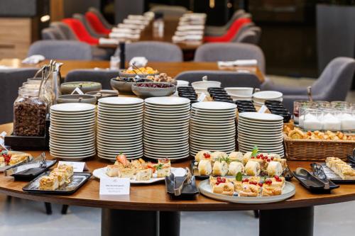 a table with plates of food on top at Qosmo Brasov Hotel in Braşov
