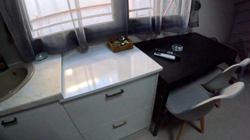a bathroom with a sink and a desk with a bottle at DATA Maisonettes and more in Chios