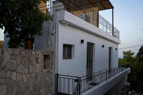 a white building with a balcony on top of it at Olea Luxury Apartment With Great View in Ierápetra