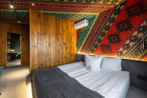 a bedroom with a bed in a room with a wall at Stara Pravda Hotel in Bukovel