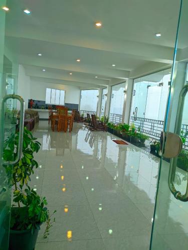 an empty lobby with tables and chairs in a building at White Home in Haputale