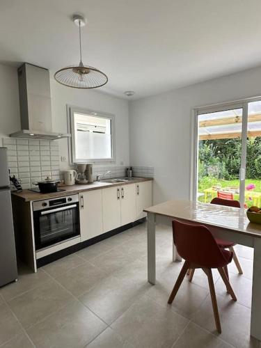 une cuisine avec une table et une table et une fenêtre dans l'établissement les Gîtes de Sophie 85 gîte Coquelicot 2 personnes, à Saint-Gervais