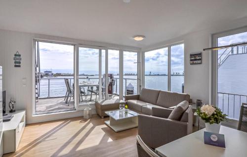 een woonkamer met een bank en uitzicht op het water bij Hausboot in Olpenitz