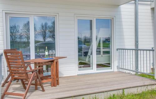 a wooden table and a chair on a porch at Fiete in Olpenitz