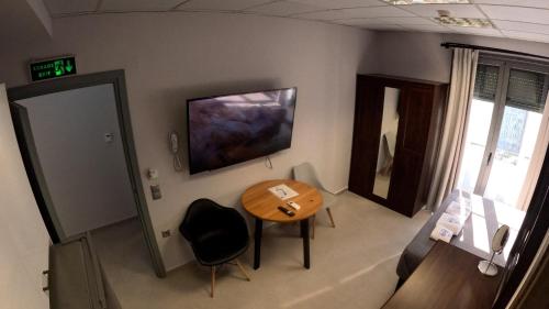 a room with a table and a television on the wall at DATA Maisonettes and more in Chios
