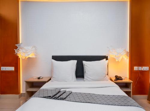 a bedroom with a large bed with white sheets and pillows at Amata n'Ubuki Boutique Hotel Ltd in Kigali
