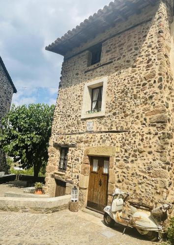 a scooter parked in front of a stone building at ViLA VELLA 1 in Santa Pau