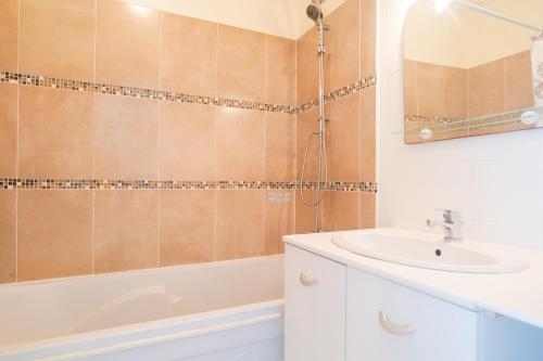 une salle de bain avec un lavabo et une baignoire dans l'établissement Appartement quartier des Présidents avec vue sur la baie des Sables d'Olonne - 4 personnes, à Les Sables-dʼOlonne