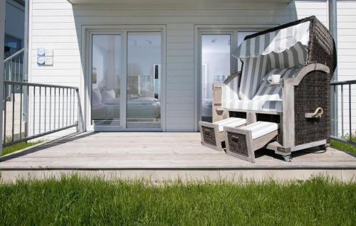 a porch with a rocking chair on a house at Albatros in Olpenitz