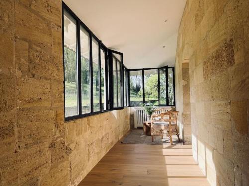 - un couloir avec des fenêtres et une table dans une chambre dans l'établissement Chateau La Clariere, à Saint-Magne-de-Castillon