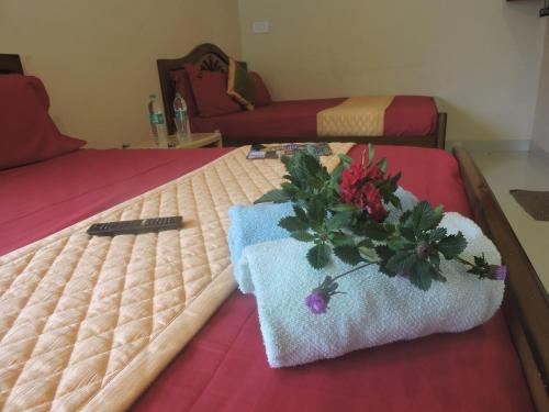 a bed with a flower arrangement on top of it at Kanna Garden by Bodhi Bungalows in Kolli Hills