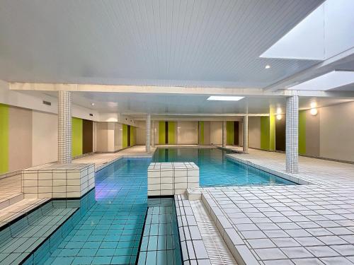 une grande piscine dans un immeuble dans l'établissement Studio tout confort avec piscine, à Périgny
