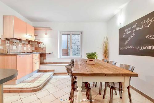 a kitchen and dining room with a wooden table and chairs at Niria - room Salice in Volastra