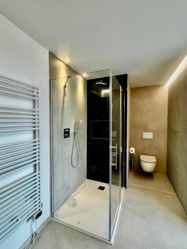 a glass shower in a bathroom with a toilet at 1Dest - Riva Luxury Stay in Riva del Garda
