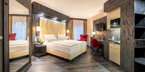 a hotel room with two beds and a desk at Best Western Hotel Schmoeker-Hof in Norderstedt