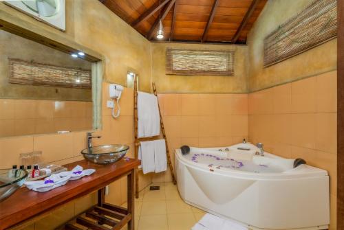 a bathroom with a tub and a sink at Athulya Villas, Kandy in Kadugannawa
