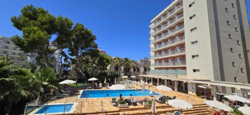 a hotel with a swimming pool next to a building at Leman Hotel y Apartamentos in Playa de Palma