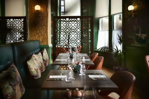 a dining room with tables and chairs and windows at The Perle Oban Hotel & Spa in Oban