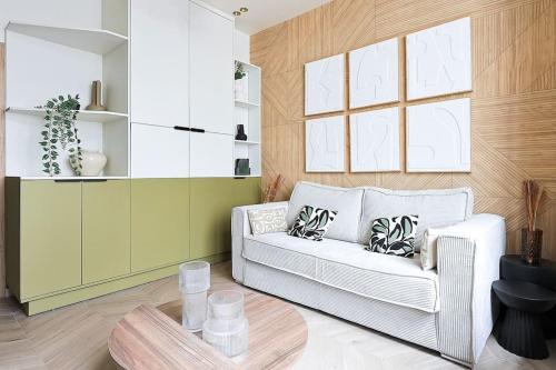 un salon avec un canapé blanc et une table dans l'établissement NEW Suite Appartement Havre Ébène 1BR 4 étoiles, à Paris