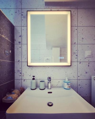 a bathroom with a sink with a mirror above it at Tararas apartments in Nea Michaniona