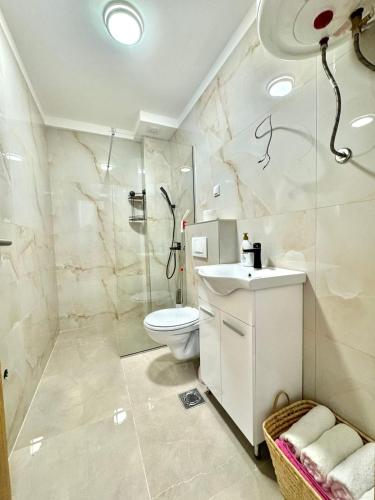 a white bathroom with a toilet and a sink at One bedroom Apartment 777 in Budva