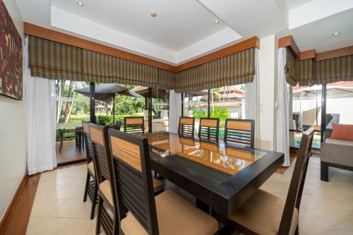a dining room with a long table and chairs at Angsana Villas Laguna-3 Bedroom Pool Villa in Phuket