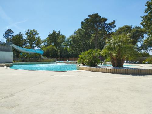 a swimming pool with a slide in a park at MOBIL - HOME 2 6p Bois de Bayadene in Piriac-sur-Mer