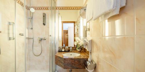 a bathroom with a sink and a shower at Best Western Hotel Schmoeker-Hof in Norderstedt