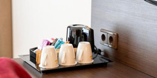 a tray with five coffee cups sitting on a table at Best Western Hotel Schmoeker-Hof in Norderstedt