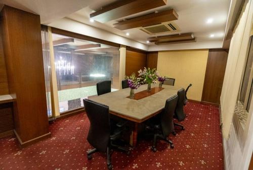 a conference room with a table with chairs and flowers at Sree Parijatha Grand in Bengaluru