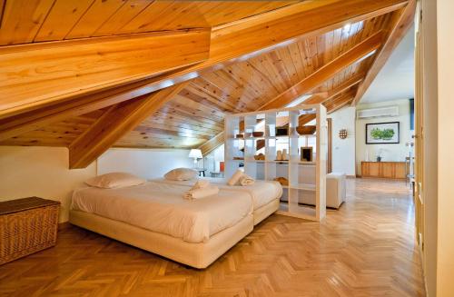 マドリードにあるApartment Latina VIIの木製の天井が特徴のベッドルーム1室(ベッド2台付)