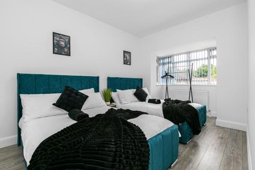 a bedroom with two beds and a couch at Spacious Detached House with 7 Beds Includes Ping Pong and Pool Table Sleeps 14 Free Parking in Feltham