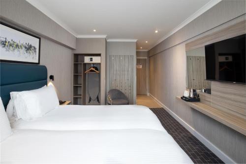a hotel room with a large bed and a tv at City Sleeper at Royal National Hotel in London