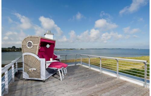 a boardwalk with a chair and a table on the water at Villa Seensucht in Olpenitz