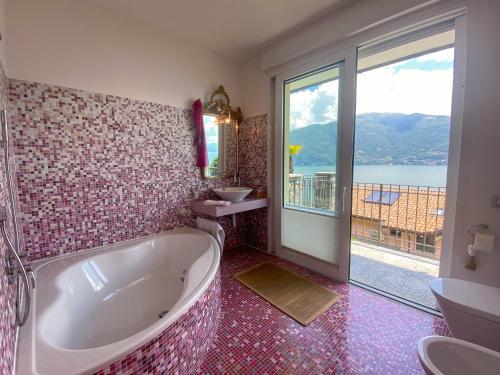 a bathroom with a tub and a sink and a window at Oasi Ulivi in San Siro