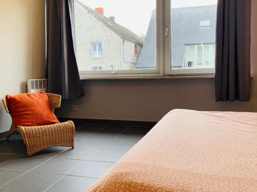 a bedroom with a bed and a window and a chair at Meuse Riverside in Hastière-par-delà