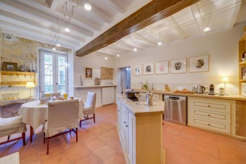 une cuisine et une salle à manger avec une table et des chaises dans l'établissement Demeure de la Combe, à Saint-Émilion