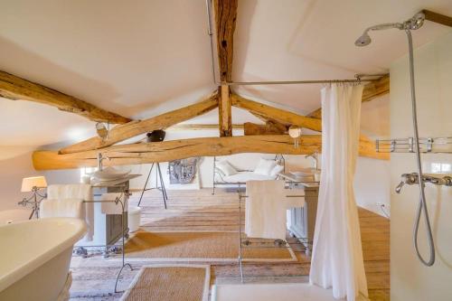 La salle de bains est pourvue d'une baignoire blanche et d'une cabine de douche. dans l'établissement Demeure de la Combe, à Saint-Émilion