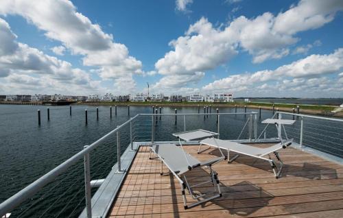 een dok met twee stoelen en een tafel op het water bij Bente in Olpenitz