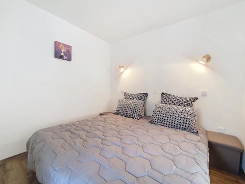a bedroom with a large bed with two pillows at Au N5 - Confort - Emplacement central - Proche Strasbourg et Europapark - Parking in Benfeld