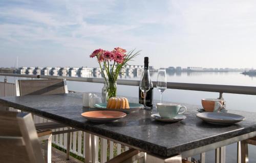 a table with a bottle of wine and a vase of flowers at Lillehuus in Olpenitz