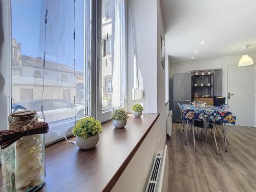 un salon avec une table et une grande fenêtre dans l'établissement Au N5 - Confort - Emplacement central - Proche Strasbourg et Europapark - Parking, à Benfeld