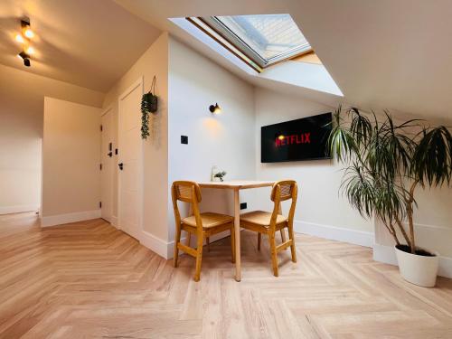 a dining room with a table and chairs and a skylight at The Nook Londons Swanky Studio with FREE Parking in London
